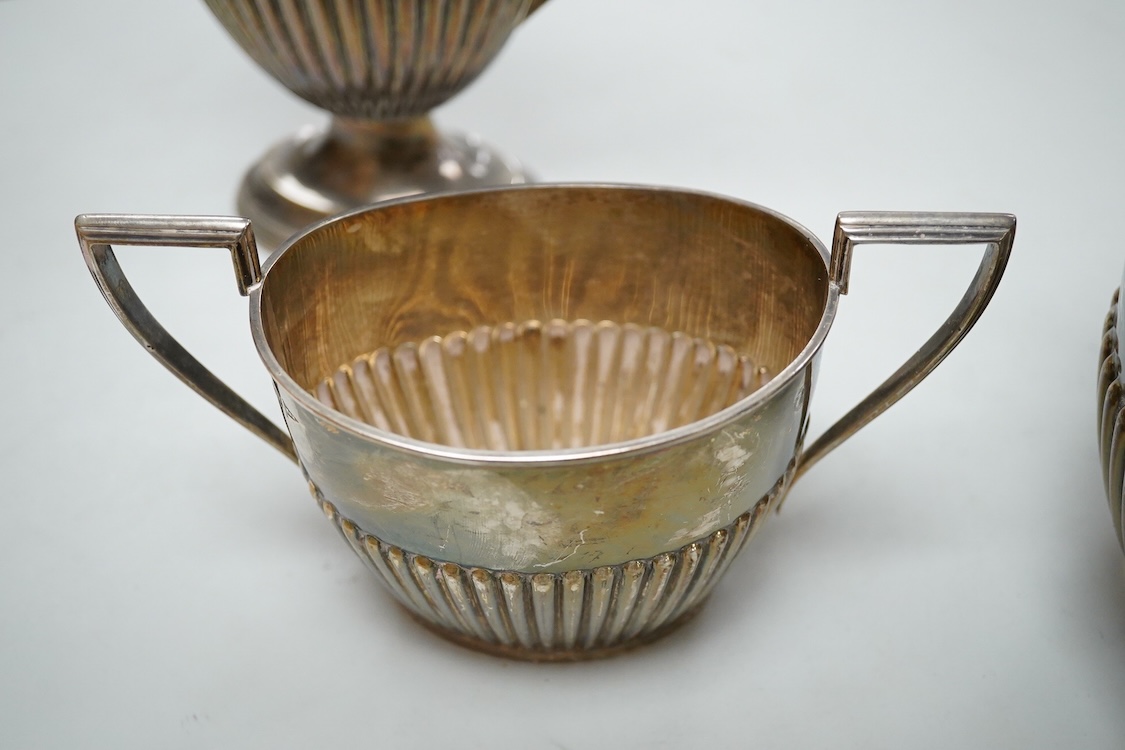 A George V demi fluted silver four piece oval tea set, comprising a teapot, hot water jug, cream jug and sugar bowl, Walker & Hall, 1910/11/12, gross weight 49oz.